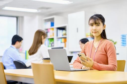 スマホを使いデスクワークする女性社員 ビジネスウーマン,スマホ,デスクワークの写真素材