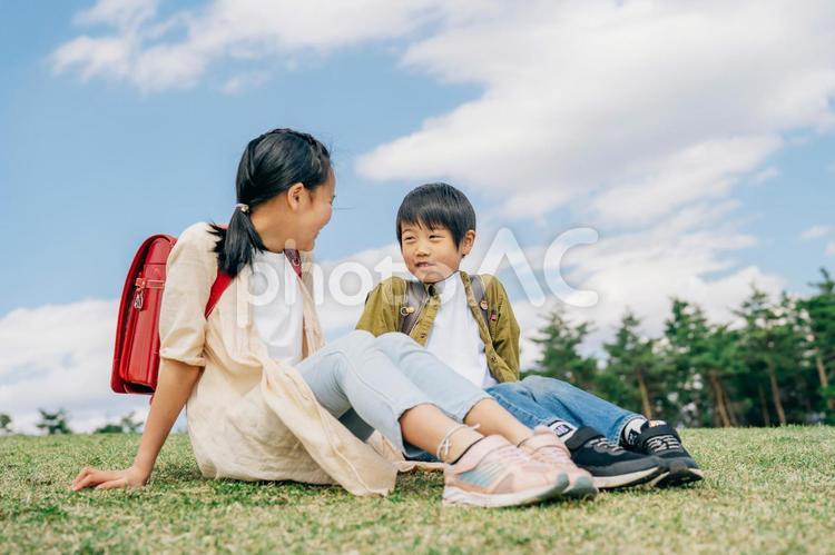 芝生に座る小学生 小学生,子供,児童の写真素材