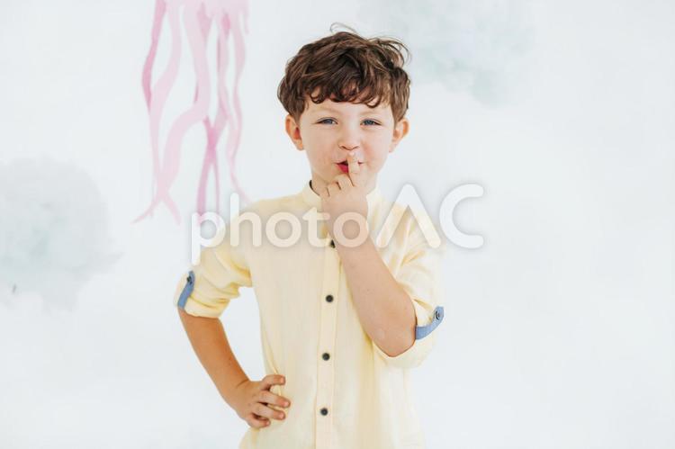 口に手を当てポーズする笑顔の子供 男の子,アート,綿の写真素材