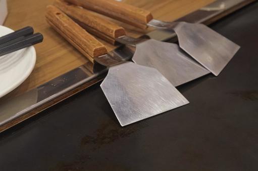 鉄板焼き用のヘラと鉄板のアップ ヘラ,コテ,もんじゃ焼きの写真素材