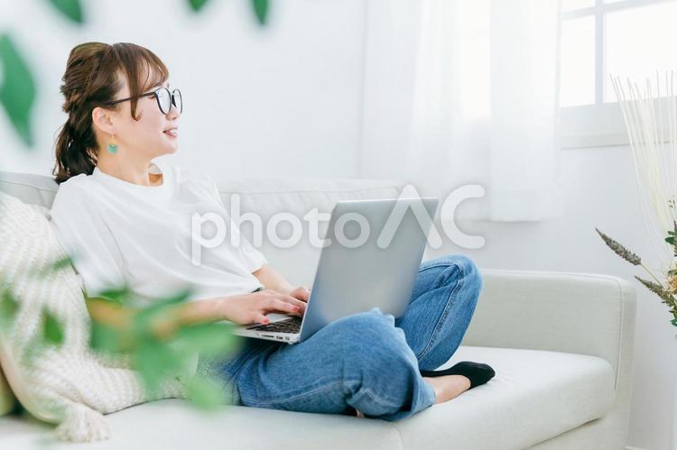 ソファでパソコンを使う女性（テレワーク） パソコン,女性,テレワークの写真素材