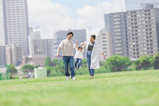 手を繋いで屋外を散歩する親子 手を繋いで屋外を散歩する親子の写真