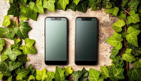 連絡交換のイメージ 机の上の携帯電話二台 連絡交換のイメージ 机の上の携帯電話二台の写真