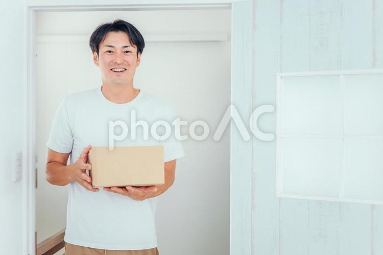 段ボールを運ぶ男性（笑顔） 通販,ネットショッピング,ダンボールの写真素材