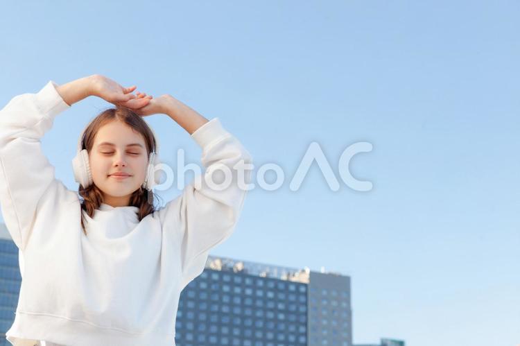歩道橋の上で目を閉じるティーンエイジャーの女の子の上半身 ティーンエイジャー,女の子,女性の写真素材