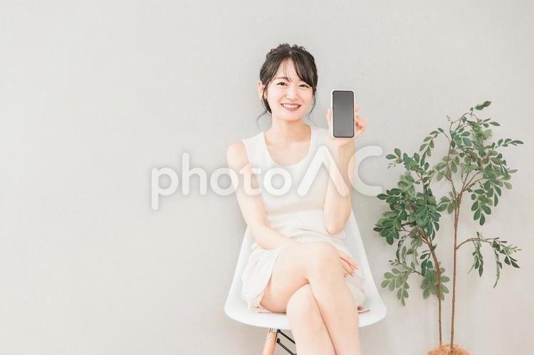 スマホの画面を見せるアジア人女性 スマホ,画面,見せるの写真素材