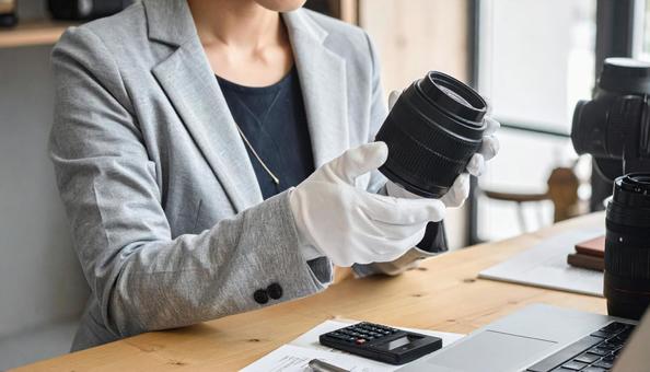 カメラのレンズを査定する女性の写真