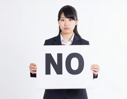 Noと書かれたボードを持つ女性社員 Noと書かれたボードを持つ女性社員の写真