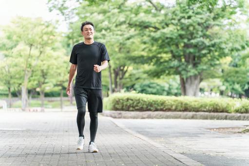 公園を散歩・ウォーキング・運動する男性 ウォーキング,有酸素運動,運動の写真素材