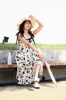 ベンチに座って景色を眺める女性 ベンチに座って景色を眺める女性の写真