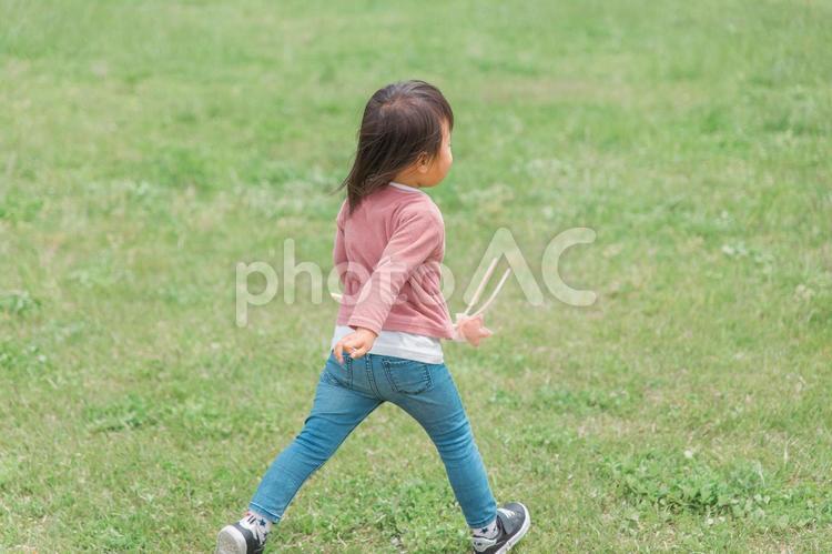 広い公園でおもちゃを持って走り回る子供 子供,女の子,子どもの写真素材