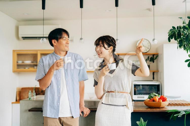 キッチンの前でコーヒーを飲む男女（夫婦） 夫婦,新婚,お茶の写真素材