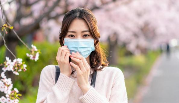マスクをして辛そうにしている日本人女性 マスクをして辛そうにしている日本人女性の写真