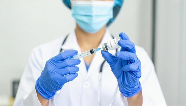 医師が注射器に薬品を充填している様子 医師が注射器に薬品を充填している様子の写真
