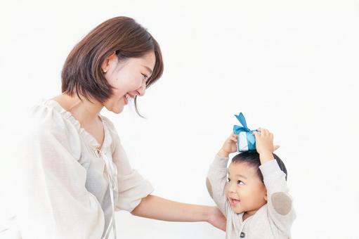 お母さんにプレゼントを渡す子ども お母さんにプレゼントを渡す子ども 母の日,男子,家族の写真素材