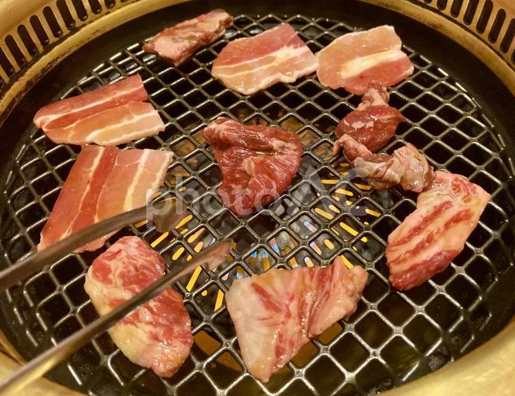 無煙ロースターで焼肉を焼くアップ・焼肉屋 無煙ロースター,焼肉,網の写真素材