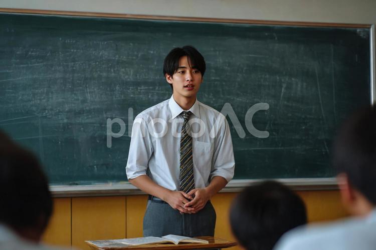 黒板の前で発表する男子生徒のイメージ 男子生徒,高校生,黒板の写真素材