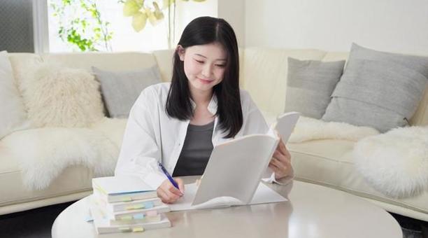 参考書で勉強をするアジア人女性 女性,学生,大学生の写真素材