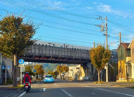 新幹線が渡る高架橋と下を通る青い車 新幹線,列車,通過の写真素材