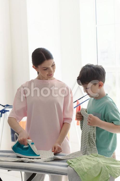 アイロンする女性と畳む男の子 親子,女性,男の子の写真素材