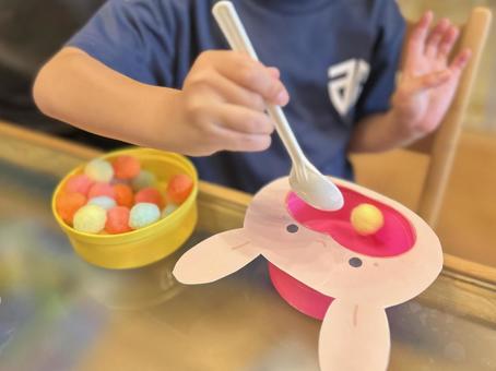 スプーンですくう練習をする子ども/横 スプーンですくう練習をする子ども/横 スプーン練習,手先の練習,子どもの写真素材