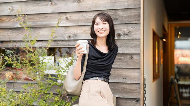 カフェでテイクアウトのコーヒーを持つ女性 カフェでテイクアウトのコーヒーを持つ女性 女性,カフェ,コーヒーの写真素材