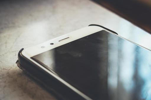 テーブルに置かれたスマートフォン 自宅療養,自宅待機,自宅の写真素材