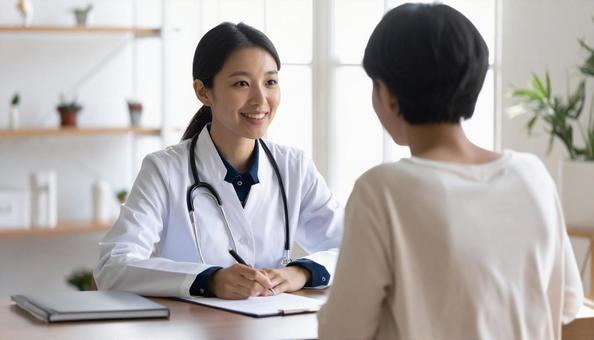 対面で問診をする若い女性医師の写真