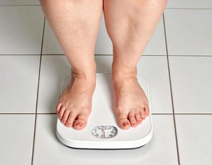 体重計にのる肥満体型の女性 ダイエット 体重計にのる肥満体型の女性 ダイエットの写真