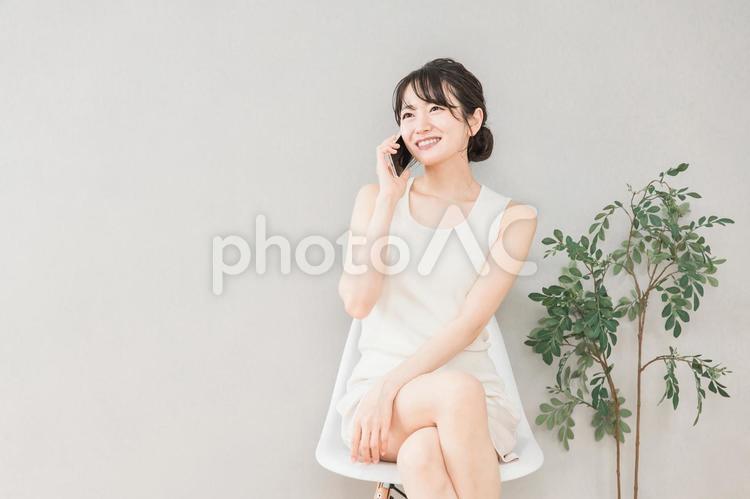 笑顔でスマホを使って電話するアジア人女性 電話,スマホ,スマートフォンの写真素材