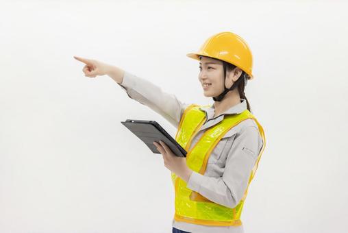タブレットを使う作業服の女性 タブレットを使う作業服の女性 女性,作業員,ヘルメットの写真素材