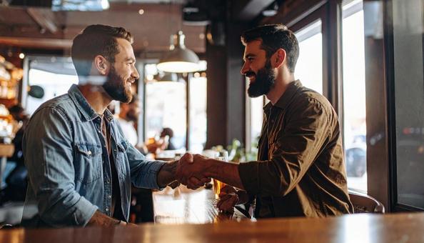 パブで握手してあいさつする外国人男性二人 パブで握手してあいさつする外国人男性二人の写真