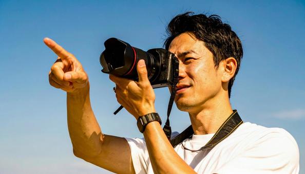 レンズを向ける日本人男性カメラマンの写真