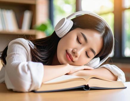 読書をしながら寝落ちする女性3 読書をしながら寝落ちする女性3の写真