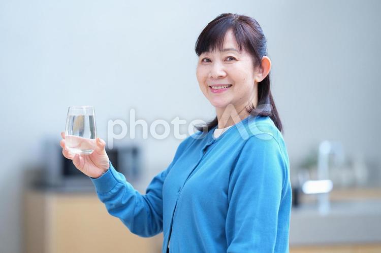 グラスの水を手に微笑む女性 主婦,家政婦,シニアの写真素材