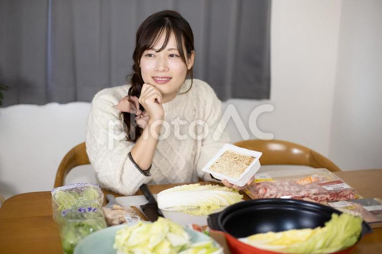 焼き豆腐を持って遠くを見るロングヘアの女性 女性,鍋パーティー,女子会の写真素材