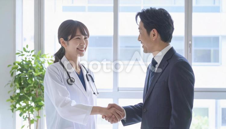 握手するビジネスパーソンと医者 握手,ビジネス,笑顔の写真素材
