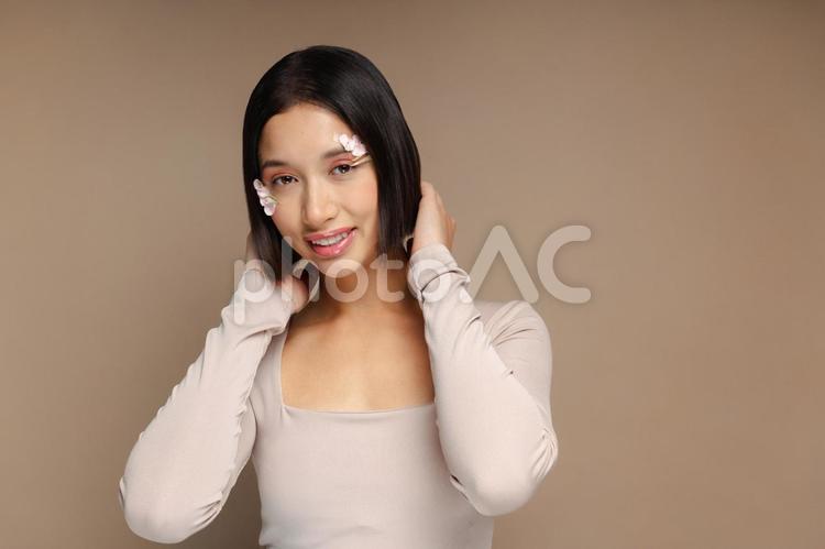 笑顔で髪を触るカメラ目線の女性 女性,髪,触るの写真素材