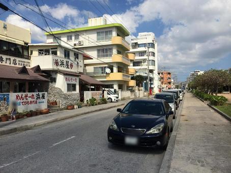 海沿いの沖縄の道路と住宅や商店の街並み 海沿いの沖縄の道路と住宅や商店の街並み 日常風景,沖縄,海沿いの写真素材