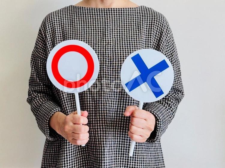 マルバツ札を持った女性（チェック柄） マルバツ,女性,判定の写真素材