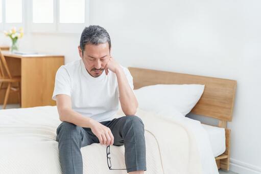 ベッドで休む疲れた表情の中高年男性 男性,中高年,疲れたの写真素材