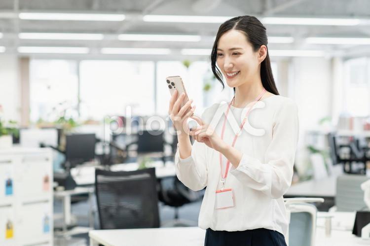 オフィスでスマホを使うビジネスウーマン ビジネスウーマン,若い,女性の写真素材