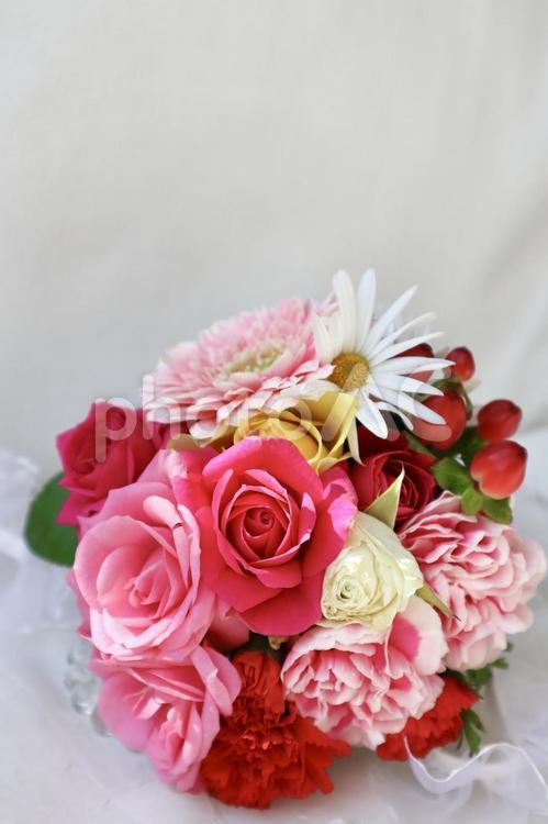 赤ピンクのブーケと陽の光  縦構図 ブーケ,花束,薔薇の写真素材