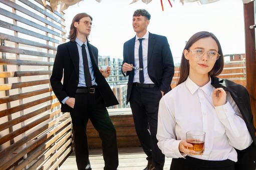 グラスを持つメガネ女性と後ろで話している男性 男女,外国人,微笑むの写真素材