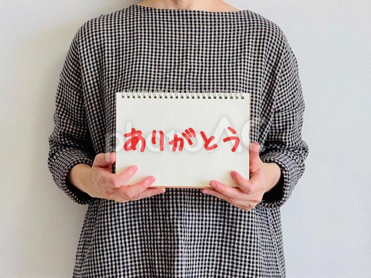 ありがとうと書かれたノートを持つ女性 ありがとう,サンキュー,感謝の写真素材
