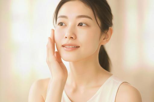 頬に触れうっとりした表情の若い女性素材 頬に触れうっとりした表情の若い女性素材の写真