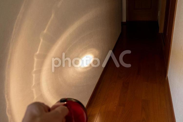 懐中電灯で暗い廊下を照らす 懐中電灯,光,壁の写真素材