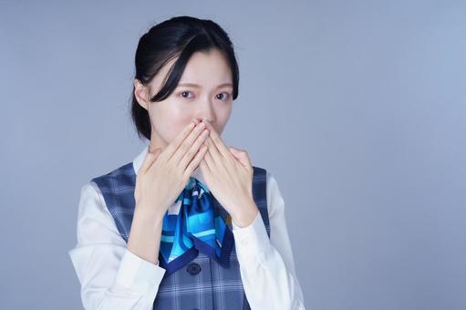 青いリボンの制服の女性が頬に手を添えるの写真