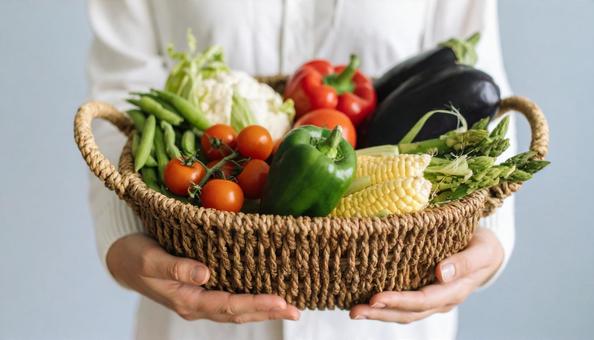 かごに入った夏野菜を持つ女性の手もと かごに入った夏野菜を持つ女性の手もとの写真