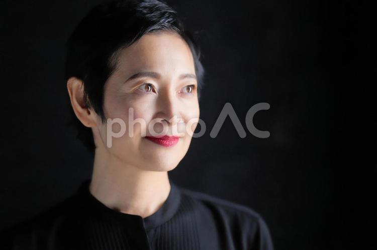 笑顔のショートカットの女性（黒背景） 女性,日本人,50代の写真素材